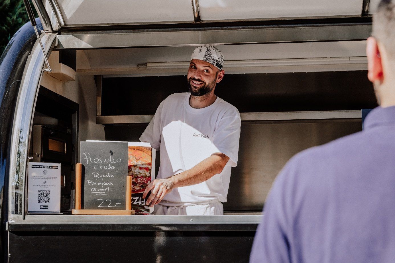 Angelo im Gespräch mit einem Kunden am Foodtruck